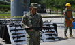 A Mexican military officer displays a machine rifle from a collection of 500 guns, part of...