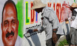 An artist paints graffiti depicting Left Democratic Front (LDF) candidate K.J. Maxy on a r...