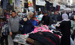 Displaced Palestinians buy from stalls at a street market ahead of Eid al-Fitr, the holida...