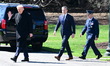 President Donald Trump waves as he departs the White House with United States Secretary of...