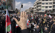 Iranian mourners holding national flags participate in a funeral for Ali Larijani, Secreta...