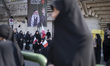 Veiled Iranian mourners gather under a portrait of Iran's late Supreme Leader, Ayatollah A...