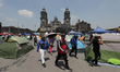 Members of the National Coordinator of Education Workers (CNTE) walk among tents during an...