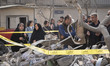 Iranian families gather behind the ruins of a building in Tehran, Iran, on March 18, 2026....