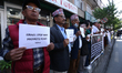 Activists from the Human Rights and Peace Society hold placards during a protest calling f...