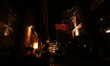 Two women apply lipstick under a neon SOHO sign on a street in the district at night in Lo...