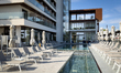The pool area of Mercure Larnaca Beach Resort is seen with loungers and part of the hotel...