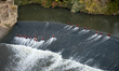 Rescue personnel in red protective suits are seen on a stepped weir of the Tagus River bel...