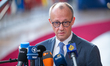 German Chancellor Friedrich Merz speaks to journalists as he arrives prior to the European...