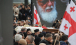 A solemn procession carries Catholicos-Patriarch of All Georgia, Ilia II, from the Holy Tr...