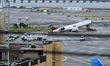 NTSB investigators work at the scene where an Air Canada jet and a Port Authority fire tru...