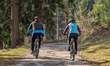 Two cyclists ride along a forest path in the Werdenfelser Land region near Garmisch-Parten...