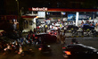 People queue to refuel their vehicles at a gas station in Hyderabad, Telangana, India, on...