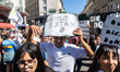 Young people participate in a march carrying placards that read, 'Where are they?', referr...