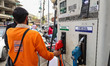 A petrol pump attendant picks up a nozzle to refuel a vehicle at an Indian Oil Corporation...