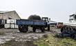 A tractor that delivered a water tank is near greenhouses in the Zaporizhzhia region, Ukra...