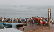 Onlookers and relatives gather at the accident site following a ferry terminal incident wh...