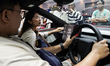 Visitors look at a Tesla Model Y electric car on display at the 47th Bangkok International...
