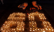 Activists light hundreds of candles arranged to spell ''60+'' to mark the Earth Hour envir...