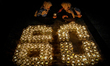 Activists light hundreds of candles arranged to spell ''60+'' to mark the Earth Hour envir...