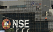 Workers are seen on scaffolding during maintenance at the National Stock Exchange building...