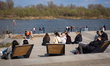 People relax on the Vistula Boulevards near the Copernicus Science Centre in Warsaw, Polan...