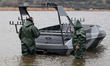 Servicemen stand next to the Barracuda drone boat during trials in southern Ukraine, on Ma...