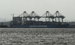 The container ship Cosco Shipping is docked at a port terminal under hazy skies in Mumbai,...