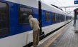 A man looks into the window of a train on the platform at Petrovaradin station in Serbia,...