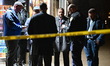 NYPD officers work at the scene where a 22-year-old man was shot in the head at a deli and...