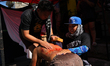 People scour the back of a kneeling penitent in Mandaluyong City, Philippines, on April 2,...