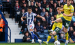 Danny Imray of West Bromwich Albion kicks the ball as George Thomason of Wrexham AFC looks...