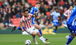 Million Manhoef of Stoke City competes with Charlie McNeill of Sheffield Wednesday during...