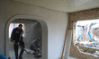 Men clear debris inside a house damaged by a drone strike in Hatne, Kyiv region, Ukraine,...