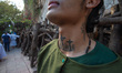 A hooded penitent prepares before the start of the Silence Procession for Holy Week celebr...