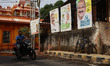 A man rides his bicycle past election campaign posters of United Democratic Front (UDF) ca...