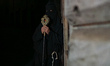 A hooded penitent from a local religious confraternity known as confratelli waits for the...