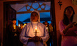 Catholic faithful light candles during the Easter Vigil candle procession at the church in...