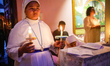 Catholic faithful hold candles during an Easter Vigil procession at a church as part of Ea...