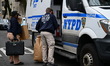 Members of the NYPD Crime Scene Unit collect evidence inside an apartment complex near Dav...