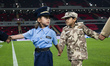 Children leave the pitch after accompanying match officials and players, dressed as member...