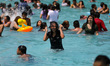 A woman enjoys getting wet in the pool at the Pantitlan Olympic Swimming area in the easte...