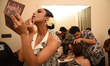 A model has her makeup applied backstage before a new summer collection fashion show hoste...