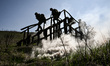 Recruits, supervised by instructors, move through an obstacle course on Day Zero of Basic...