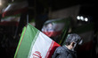 An Iranian man carrying a national flag participates in a pro-government rally in downtown...