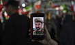 A woman displays an AI-generated image of Iran's new Supreme Leader, Ayatollah Mojtaba Kha...
