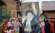 Shiite Muslim women carry a portrait of Iran's late Supreme Leader Ayatollah Ali Khamenei...