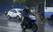 A motorcyclist rides through rain along a street in Kathmandu, Nepal, on April 8, 2026, as...