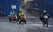 Motorcyclists ride through rain along a street in Kathmandu, Nepal, on April 8, 2026, as a...