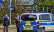 Police officers stand beside police vehicles during a search for a person near Bad Wimpfen...